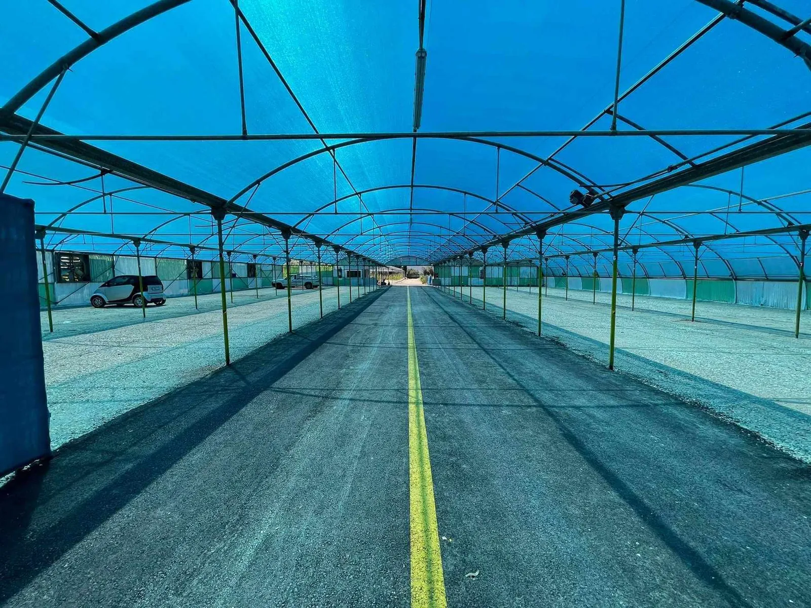 A shaded parking aisle at K1 Parking under blue shade netting